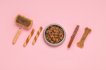 Composition with pet collar, grooming brush and food on pink background