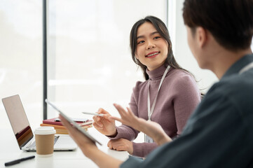 A female marketing assistant is listening to her colleague's ideas and working together.