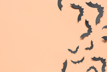 Fototapeta na wymiar Paper bats for Halloween party on orange background