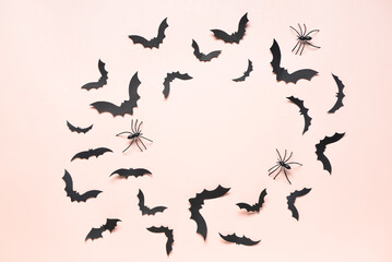 Frame made of paper bats and spiders for Halloween party on pink background