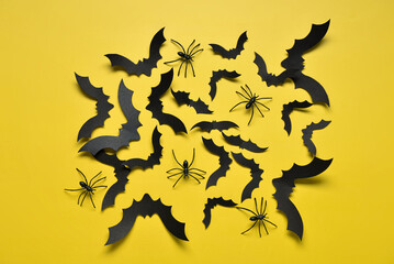 Naklejka premium Paper bats and spiders for Halloween party on yellow background