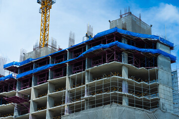 Construction site background. Hoisting cranes and new multi-storey buildings. Industrial background. Building construction site work against blue sky.monolithic technology.