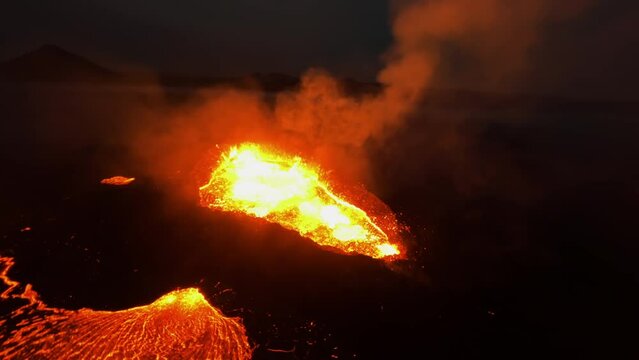 FPV drone shot around a smoking lava outburst, night at the Litli-Hrutur volcano