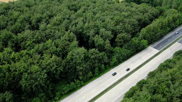 Aerial view crossing Hampshire motorway towards Micheldever crop circle patterns formed on golden wheat farmland 2023