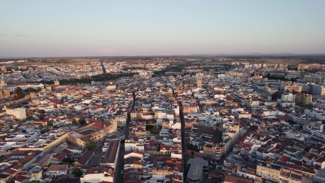 Aerial orbiting shot of Badajoz Cityscape during sunset, Spain