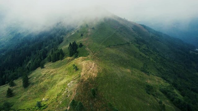 Clouds on Mountain from a Drone, Monviso, Italy. The low clouds are coming up on the side of the mountain, slowly coming over the green summer landscape