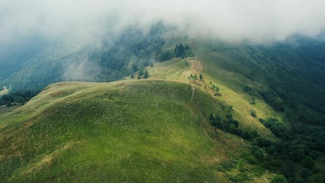 Clouds on Mountain from a Drone, Monviso, Italy. The low clouds are coming up on the side of the mountain, slowly coming over the green summer landscape