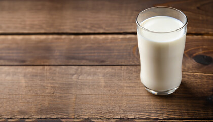 Full glass of milk on brown rustic wooden background