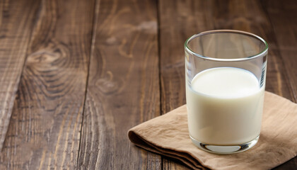 Full glass of milk on brown rustic wooden background