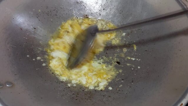Scrambled eggs or omelette with butter and oil. Mixing egg in pan with spatula. Cooking Eggs for Breakfast