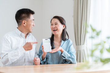 計算機を持つシニア夫婦（老後・お金・貯金）