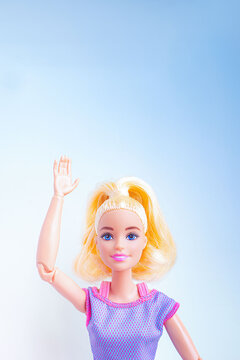 片手を上に挙げるジェスチャーをしているバービー人形 - 挨拶や挙手する女性のイメージ素材
