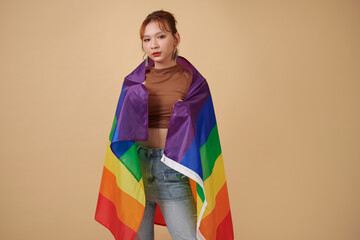 Young transgender woman wrapping in striped flag