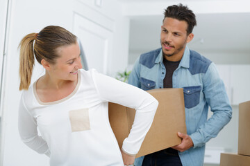 Fototapeta premium young couple carrying big cardboard box in new home