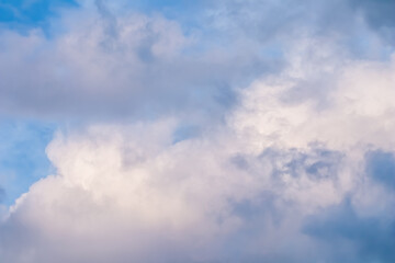 Blue sky background with white and pink clouds at sunset