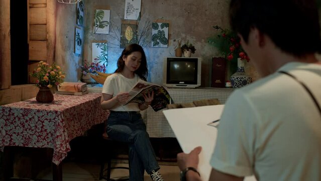 man draws his young wife reading a magazine