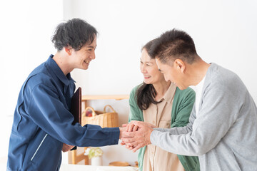 Obraz premium 握手する業者と高齢者夫婦（引越し・内見・見積り・相談）