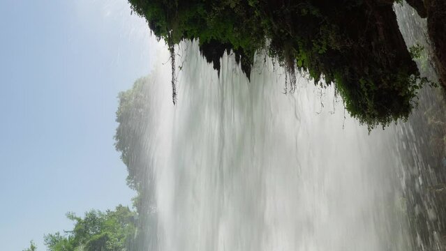 Behind Waterfall low shot summer sunny day forest national park bluw sky