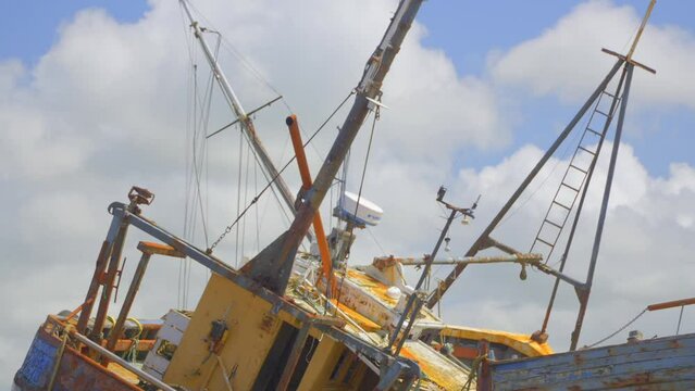 Rusty shipwreck with clouds racing by behind. Time lapse 30x.