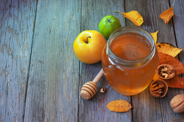 Fresh honey with pollen on an old wooden table. Autumn background with apples, walnuts and honey. Rural motive with food and fallen leaves. top view