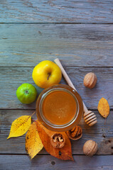 Fresh honey with pollen on an old wooden table. Autumn background with apples, walnuts and honey. Rural motive with food and fallen leaves. top view