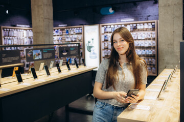 Close up of a girl in a tech store, exploring new smart phone.