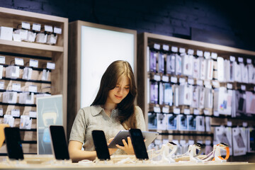 woman choosing a new mobile phone in a shop