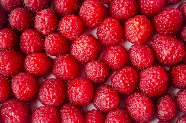 On the table lies a bright juicy raspberry.  Background of bright garden, forest raspberries.  Flat lay, top view.  Concept agriculture.  Background picture.