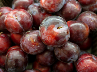 A pile of red plum fruits Prunus americana in the supermarket