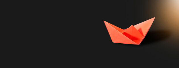 a dark background with a red paper boat It's really difficult to launch a successful firm. , starting a new company