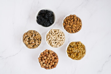 Various nuts and dried fruits in white bowl