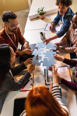 Group of professional people playing puzzle in the office.Team Building