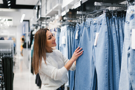 Caucasian woman chooses jeans, casual clothes in the store