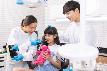 Happy female dentist with patient girl at clinic.Asian children's dentistry for healthy teeth and beautiful smile .