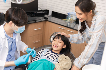 Happy asian male dentist with patient girl at clinic.Asian children's dentistry for healthy teeth and beautiful smile .