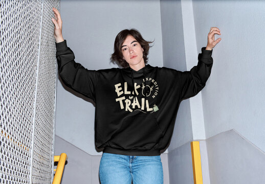 Mockup of woman wearing long sleeve top with customizable color in stairwell, camera flash