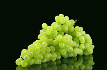 Bunch of green grapes with water drops on black background