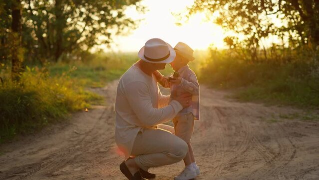 A man comforts and hugs his little son