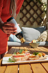 close-up of a woman preparing light snacks on the balcony, uses balsamic sauce