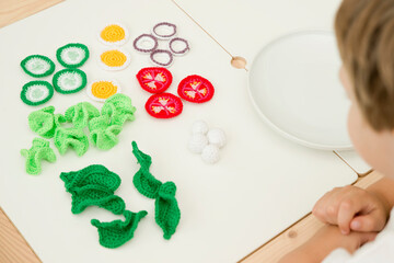 Handmade crocheted salad. Healthy breakfast, kitchen toys for preschoolers. Sensory cooking games at home to develop children's imagination. Classic recipe.