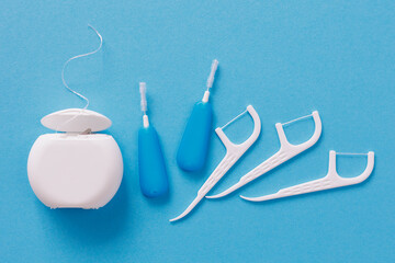 Top view of dental toothpicks and floss on blue - obrazy, fototapety, plakaty