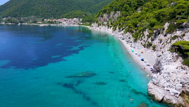 Aerial view of the beautiful Hovolo beach, Sporades, Greece, with turquoise sea and lush pine tree forest