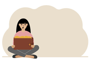 A woman sits cross-legged and holds a large purse of coins. The concept of a savings wallet, a successful loan, golden earnings with metal money in the currency.