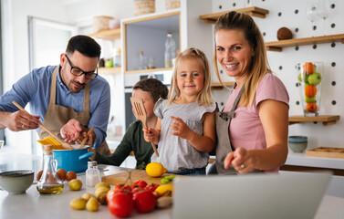 Happy family preparing healthy food together in kitchen. People happiness cooking concept