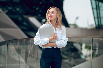 Long-haired young woman in office clothes looking confident