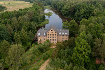 Fototapeta na wymiar The ancient Katrina mill building in a picturesque location by the lake, Krimulda, Latvia