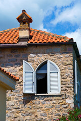 street view of the old town of Budva in Montenegro, medieval European architecture, city streets, windows with wooden shutters, red tiled roofs, the concept of traveling through the Balkans
