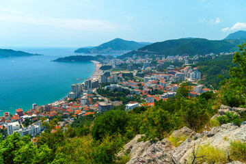 Naklejka na ściany i meble aerial view of the city on the seashore and mountains, panorama of the resorts of Becici and Budva in Montenegro, Adriatic sea, beaches, islands, tourism and travel, summer traveling