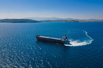 Aerial shot of Bulk carrier ship manoeuvring in anchorage in sea