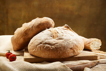 Composition with whole grain bread with fresh tomatoes on rustic wooden board closeup.